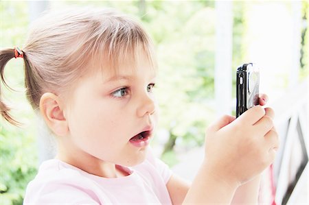 surprised girl - Toddler playing with cell phone Stock Photo - Premium Royalty-Free, Code: 649-06305856