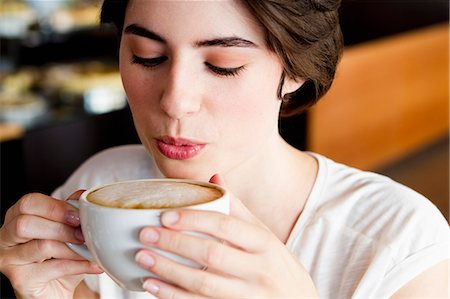 Woman blowing on coffee in cafe Stock Photo - Premium Royalty-Free, Code: 649-06352535