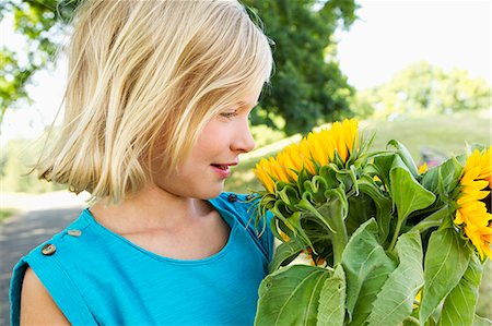 pretty girl in happy - Smiling girl carrying sunflowers Stock Photo - Premium Royalty-Free, Code: 649-06352618