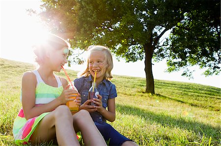 people in fields - Laughing girls drinking juice outdoors Stock Photo - Premium Royalty-Free, Code: 649-06352649