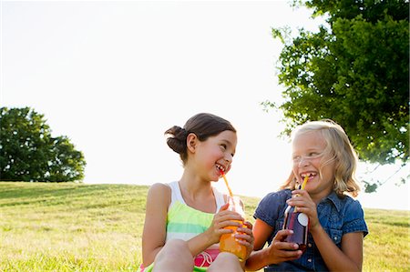 softdrink - Laughing girls drinking juice outdoors Stock Photo - Premium Royalty-Free, Code: 649-06352650