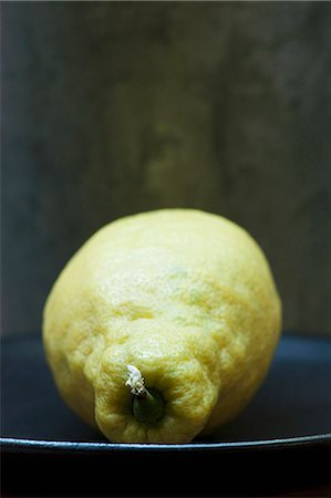 single lemon - Close up of unwaxed lemon on plate Stock Photo - Premium Royalty-Free, Code: 649-06352888