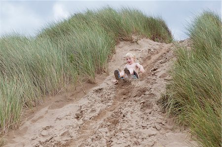 fun falling - Garçon glisser vers le bas de la dune de sable Photographie de stock - Premium Libres de Droits, Code: 649-06352906