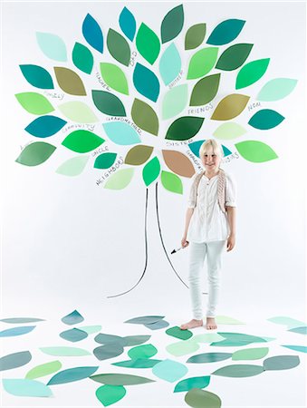 Girl standing under tree on wall Stock Photo - Premium Royalty-Free, Code: 649-06352954