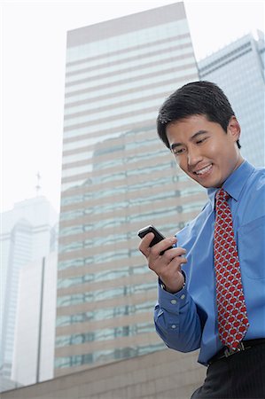simsearch:649-07520071,k - Businessman using cell phone outdoors Stock Photo - Premium Royalty-Free, Code: 649-06353468