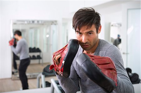 Trainer wearing padded gloves in gym Stock Photo - Premium Royalty-Free, Code: 649-06400806