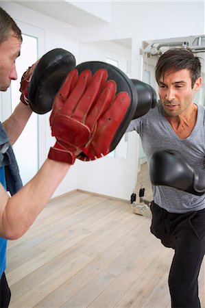 senior sports - Boxer practicing with trainer in gym Stock Photo - Premium Royalty-Free, Code: 649-06400801