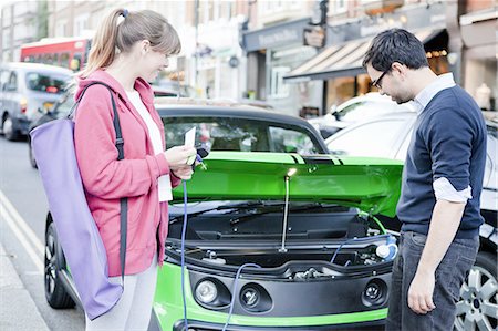 Couple charging electric car on street Stock Photo - Premium Royalty-Free, Code: 649-06401141