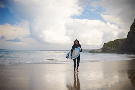 simsearch:673-06964643,k - Surfer carrying board on beach Stock Photo - Premium Royalty-Free, Code: 649-06401180