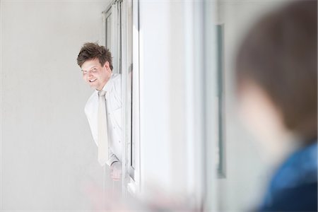 flirting - Businessman leaning out window Stock Photo - Premium Royalty-Free, Code: 649-06432307