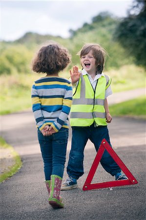 Boy playing traffic worker on rural road Stock Photo - Premium Royalty-Free, Code: 649-06432498