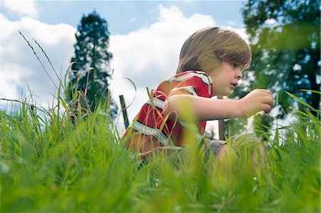 Boy playing in grassy field Stock Photo - Premium Royalty-Free, Code: 649-06432505