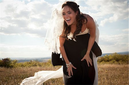 simsearch:649-06432557,k - Newlywed groom carrying bride outdoors Stock Photo - Premium Royalty-Free, Code: 649-06432568
