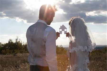 rear view of a woman - Newlywed couple holding a picture of a house Stock Photo - Premium Royalty-Free, Code: 649-06432576