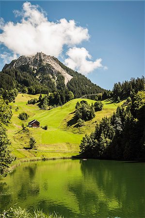 Grassy hillside by still rural lake Stock Photo - Premium Royalty-Free, Code: 649-06433202