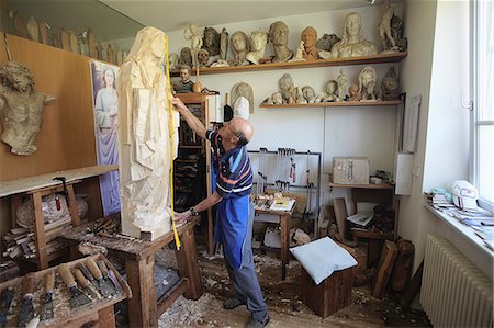 Sculptor measuring wooden figure Stock Photo - Premium Royalty-Free, Code: 649-06433387