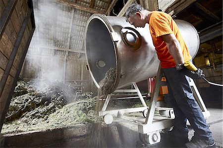 Worker pouring mixture from vat in shop Stock Photo - Premium Royalty-Free, Code: 649-06433452