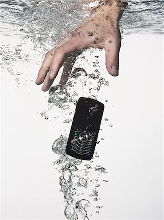 dropped - Hand grasping cell phone in water Stock Photo - Premium Royalty-Free, Code: 649-06433662