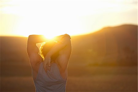 Man stretching in field at sunset Stock Photo - Premium Royalty-Free, Code: 649-06488590