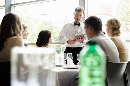 restaurant adults group - Waiter taking order with tablet computer Stock Photo - Premium Royalty-Free, Code: 649-06488813