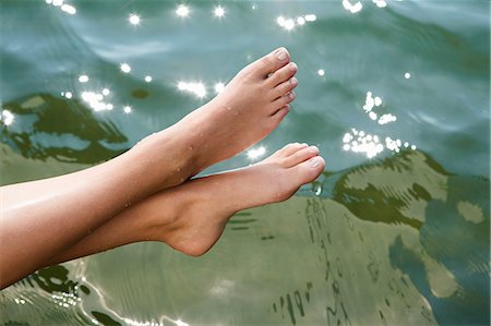 Woman dipping toes into still lake Stock Photo - Premium Royalty-Free, Code: 649-06489150