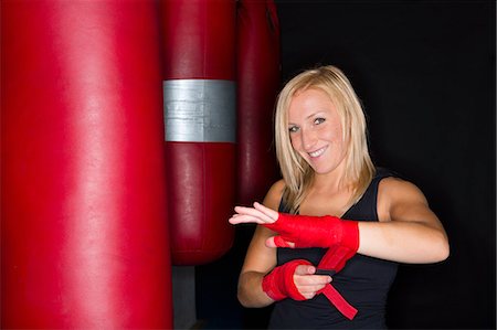 Boxer wrapping her hands in gym Stock Photo - Premium Royalty-Free, Code: 649-06489191