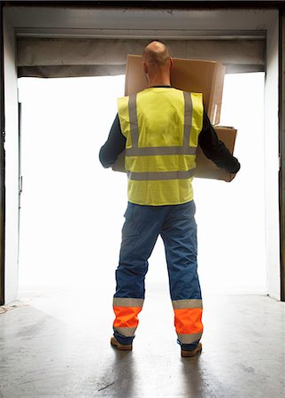 Worker carrying boxes in warehouse Stock Photo - Premium Royalty-Free, Code: 649-06489260