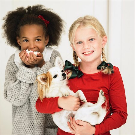 dog christmas pictures - Girls eating popcorn and holding dog Stock Photo - Premium Royalty-Free, Code: 649-06489281