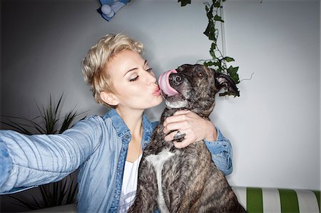 dogs licking women - Smiling woman taking picture with dog Stock Photo - Premium Royalty-Free, Code: 649-06490066