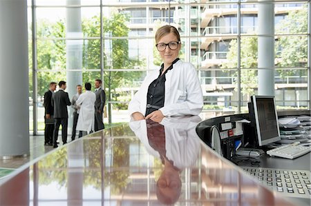 sale - Doctor leaning on secretarys desk Stock Photo - Premium Royalty-Free, Code: 649-06532626