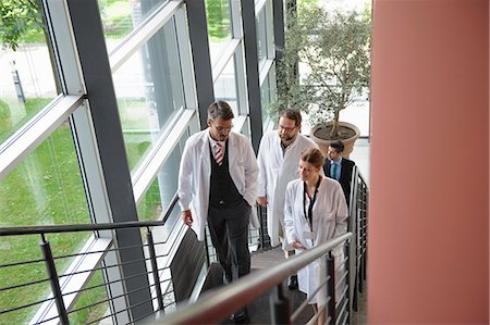 doctors with person in a suit - Doctors climbing staircase in office Stock Photo - Premium Royalty-Free, Code: 649-06532641