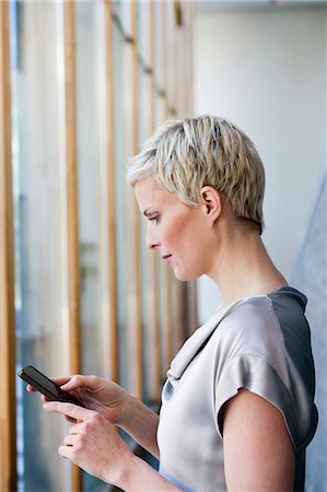 Woman using cell phone outdoors Stock Photo - Premium Royalty-Free, Code: 649-06532704