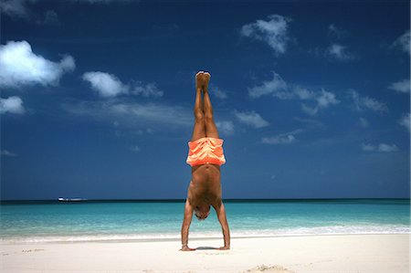 simsearch:633-01714467,k - Man doing handstand on tropical beach Stock Photo - Premium Royalty-Free, Code: 649-06533005