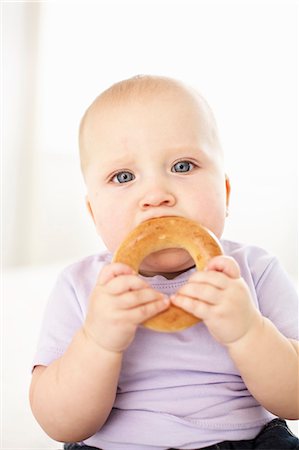 Baby girl eating bagel Foto de stock - Sin royalties Premium, Código: 649-06533394