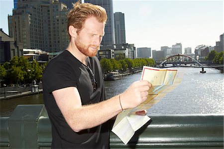 Man reading city map on bridge Stock Photo - Premium Royalty-Free, Code: 649-06622236