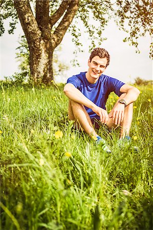 Smiling man sitting in tall grass Stock Photo - Premium Royalty-Free, Code: 649-06623010