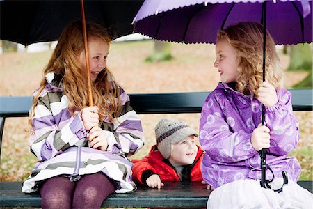 simsearch:649-05657687,k - Girls with umbrellas on park bench Photographie de stock - Premium Libres de Droits, Code: 649-06623071