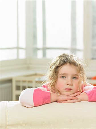 picture kid sad window - Girl leaning on sofa in living room Stock Photo - Premium Royalty-Free, Code: 649-06716537