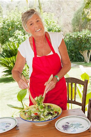 Older woman tossing salad outdoors Stock Photo - Premium Royalty-Free, Code: 649-06716670
