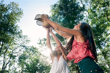 Teenage girls playing with straw hat Stock Photo - Premium Royalty-Free, Code: 649-06716816