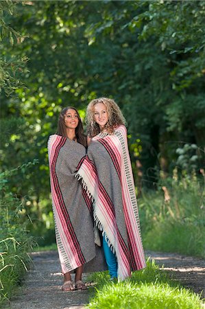 Teenage girls in blanket on rural road Stock Photo - Premium Royalty-Free, Code: 649-06716810
