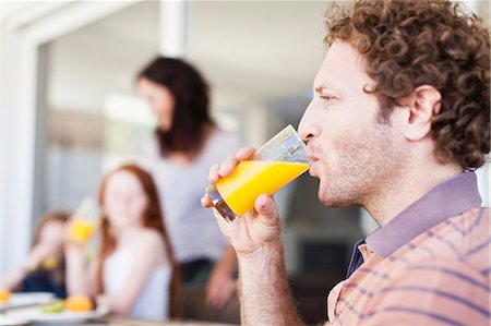 simsearch:649-06717020,k - Man drinking glass of orange juice Stock Photo - Premium Royalty-Free, Code: 649-06716965