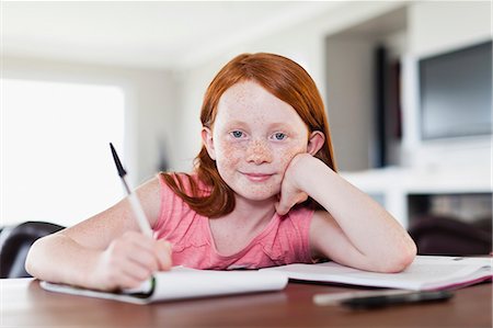 red hair preteen girl - Smiling girl doing homework Foto de stock - Sin royalties Premium, Código: 649-06716998