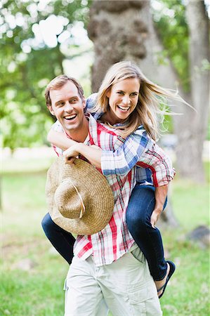 Man carrying girlfriend in park Stock Photo - Premium Royalty-Free, Code: 649-06717251