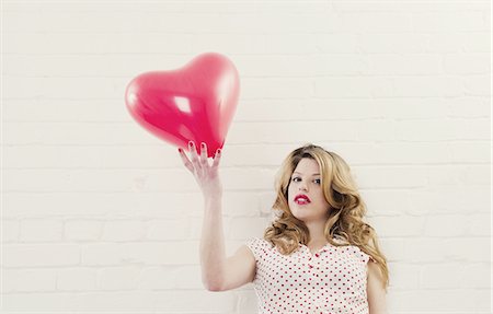 Woman holding heart shaped balloon Photographie de stock - Premium Libres de Droits, Code: 649-06717614