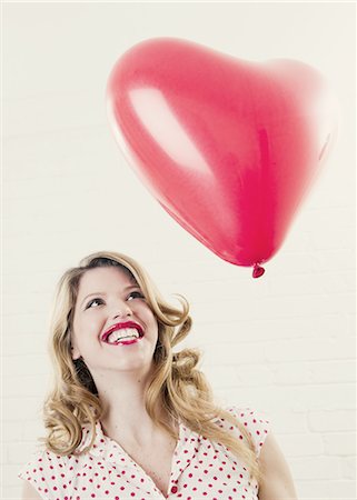 simsearch:649-06717611,k - Smiling woman with heart shaped balloon Foto de stock - Sin royalties Premium, Código: 649-06717612