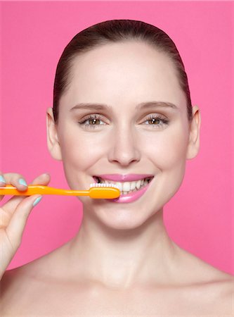 simsearch:649-06305009,k - Smiling woman brushing her teeth Stock Photo - Premium Royalty-Free, Code: 649-06717826