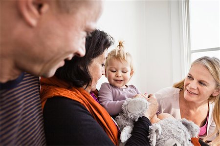 senior female candid - Grandmother holding toddler granddaughter with parents Stock Photo - Premium Royalty-Free, Code: 649-06812258