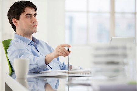 Businessman sitting at desk working Stock Photo - Premium Royalty-Free, Code: 649-06812596