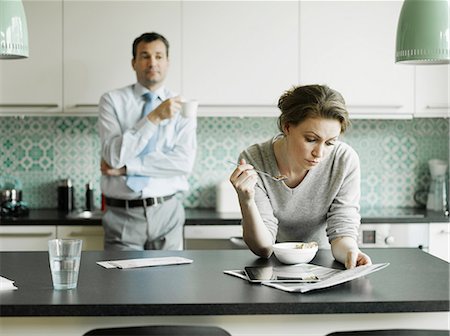 Mid adult woman reading document over breakfast in kitchen Stock Photo - Premium Royalty-Free, Code: 649-06829627